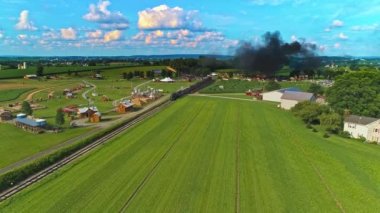 Amish Çiftliği 'nin havadan görünüşü Tek bir tren yolu ve Buharlı Yolcu Treni yaklaşıyor.