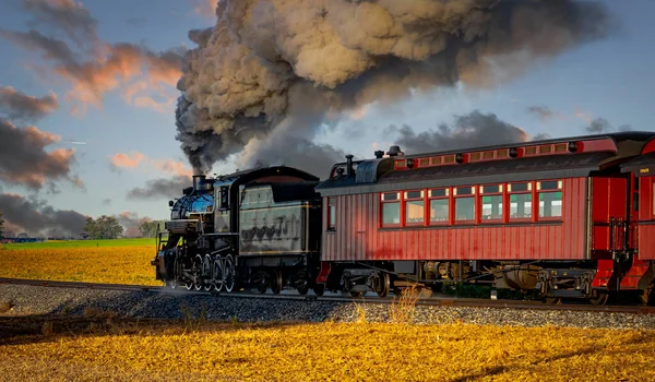 Vista de un antiguo tren de vapor de pasajeros que sopla humo Traveling Pass al amanecer —  Fotos de Stock