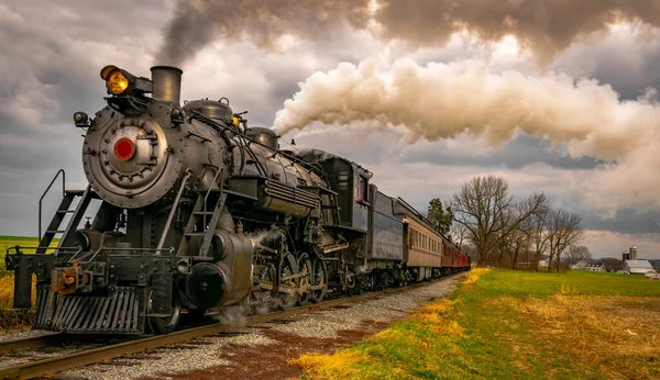 Chiudi Veduta di un treno passeggeri in avvicinamento a vapore che viaggia attraverso i terreni agricoli — Foto Stock