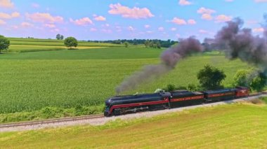 Ronks, Pensilvanya, 23 Temmuz 2021 - Güneşli bir Yaz Günü 'nde Siyah Duman Eken Bir Yolcu Treni Paralel Görünümü