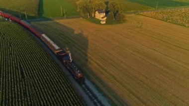 Buharlı Yolcu Treni 'nin Bir Yaz Günü Altın Saati sırasında Thru Mısır Tarlaları ve Tarım Alanlarından Geçişi Hava Önü Görünümü