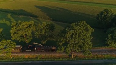 Ronks, Pennsylvania, 30 Temmuz 2021 - Bir Yaz Saati sırasında Thru Mısır Tarlaları ve Tarım Alanlarından Geçen Buharlı Yolcu Treni Paralel Görünümü