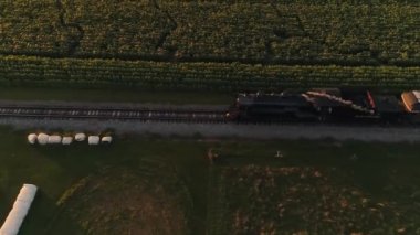 Ronks, Pennsylvania, 30 Temmuz 2021 - Bir Yaz Saati sırasında Thru Mısır Tarlaları ve Tarım Alanlarından Geçen Buharlı Yolcu Treninin Hava Görünümü
