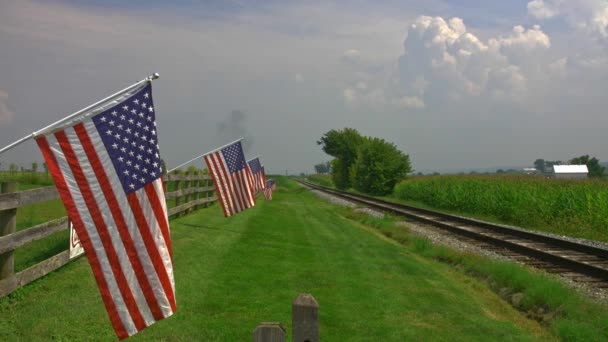 Widok Linii Delikatnie Machającej Amerykańską Flagą Płocie Przez Pola Uprawne — Wideo stockowe