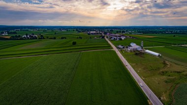 Ahır ve siloları olan tarlaların havadan görünüşü tepeleri ve tarlaları inceliyor.