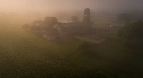 Letecký pohled na hustou mlhu pokrývající farmy a usedlosti — Stock fotografie