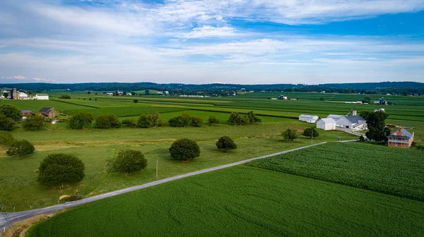 Vista aérea de terras agrícolas com celeiros e silos, olhando sobre as colinas e campos — Fotografia de Stock