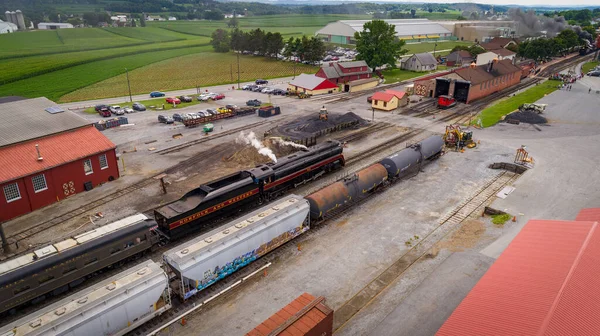 Drone View of a Steam Utasszállító vonat halad át egy teherpályaudvar közeledik egy állomás — Stock Fotó