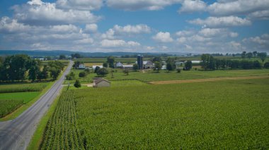 Drone View of Amish Countryside With Barns and Silos, a Patch Work of Corps and Farmlands on Sunny Day.