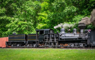 A View of an Antique Shay Steam Engine Warming Up, Blowing Smoke and Steam on a Sunny Day