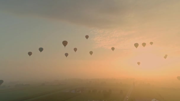 バルーンフェスティバル中に霧の中に浮かぶ複数の熱気球のドローンビュー — ストック動画