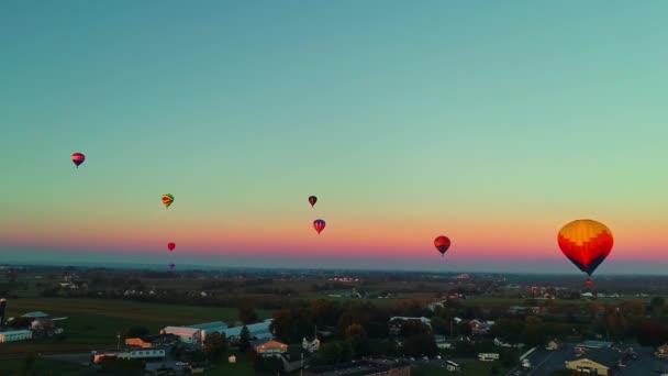 早朝の空に浮かぶ熱気球のドローンビュー 赤い空のバルーンフェスティバル — ストック動画