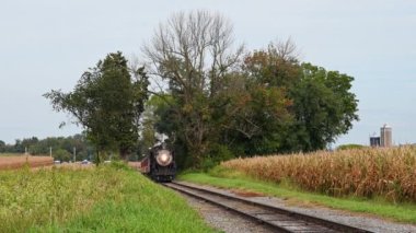 View of a Steam Passenger Train Approaching Slowly Along a Single Track in Rural America on a Fall Day