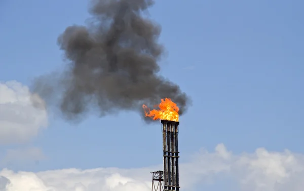 Refinaria de óleo com fogo e fumaça — Fotografia de Stock