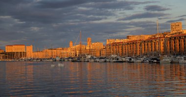 Fransa, Marsilya 'nın eski limanında gün doğumu, eğlence tekneleri ve tarihi binalarla