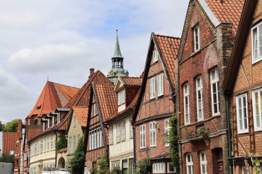 Tarihi evlerin Gables 'ı ve Almanya' nın Luneburg kentindeki St.Michaelis kilisesinin kilise kulesi.