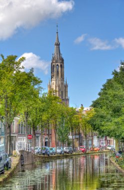 Delft, Hollanda 'daki Nieuwe Kerk Kilisesi tarihi merkezin ev ve ağaçlarının üzerinde.
