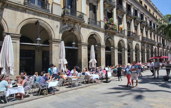Barselona, İspanya - 22 Mayıs 2015: Turistler 22 Mayıs 2015 tarihinde İspanya 'nın Barselona kentindeki Placa Reial kentindeki restoranların önünden geçtiler.