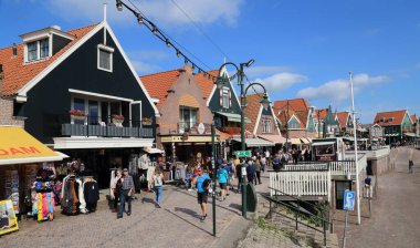 Volendam, The Netherlands - September 12, 2019: Tourists walk along historical houses and souvenir shops in Volendam, The Netherlands on September 12, 2019
