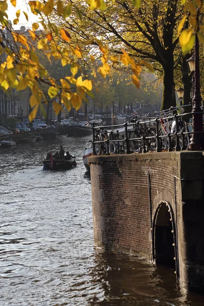 荷兰阿姆斯特丹 2016年11月11日 2016年11月11日 在荷兰阿姆斯特丹 人们乘小船通过一条横跨一条长满秋树的运河的桥 — 图库照片