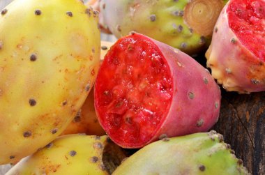 Tahta bir masada kırmızı ve sarı Opuntia incir ağacı. Tropik tatlı tatlı tatlı tatlı, yiyecek ve sağlık konsepti. Seçici odaklanma.