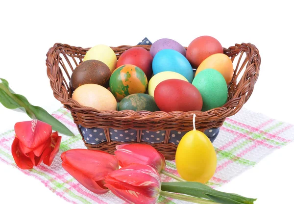 Sepetteki renkli Paskalya yumurtalarını ve izole edilmiş beyaz arka plandaki renkli lale süslerini kapat.