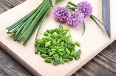 Siberian onion - Allium Schoenoprasum, cut on a plank. Vegetarian food and culinary use. Spices and fresh food. clipart