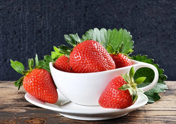 在深色木制背景的碗里放新鲜草莓 — 图库照片