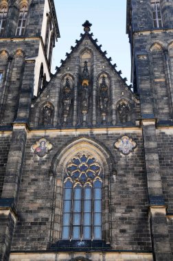 Gothic facade of the main Prague basilica - the Basilica of Saint Peter and Saint Paul. A circular rosette above the entrance portal and tall columns. The current building itself was built in the Neo-Gothic style.