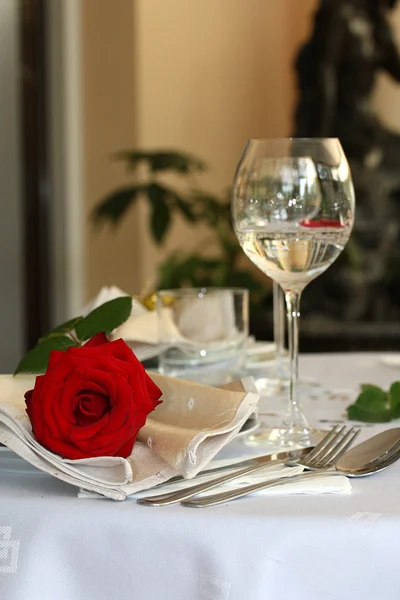 Restaurant table with glasses and rose