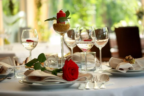 Restaurant table with glasses and rose