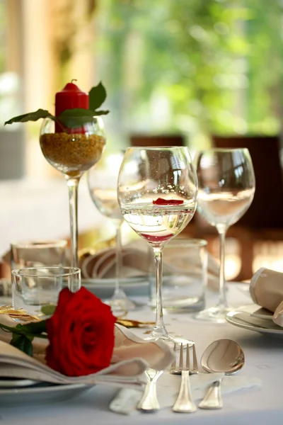 Restaurant table with glasses and rose