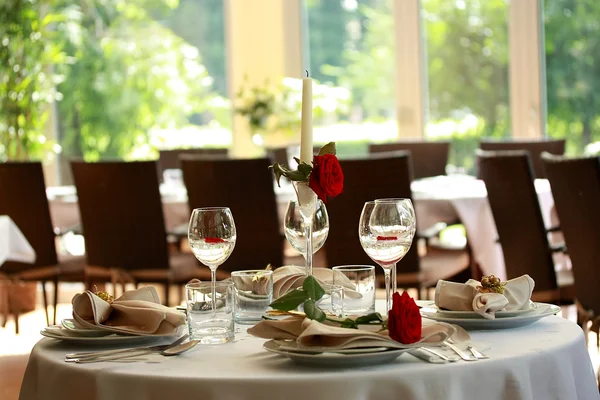 Restaurant table with glasses and roses — Stock Photo, Image