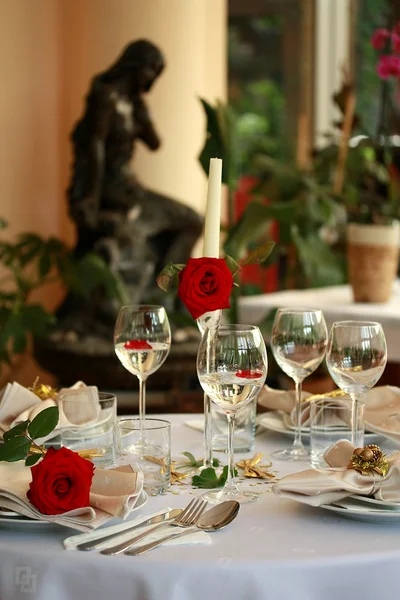 Restaurant table with glasses and rose