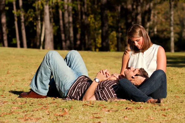 Jeune couple amoureux étendu sur champ herbeux — Photo