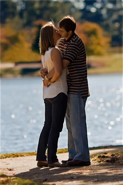 Mladý pár v lásce polibek od jezera — Stock fotografie