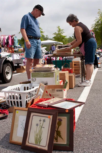 Senior man kijkt over merchandise bij garageverkoop — Stockfoto