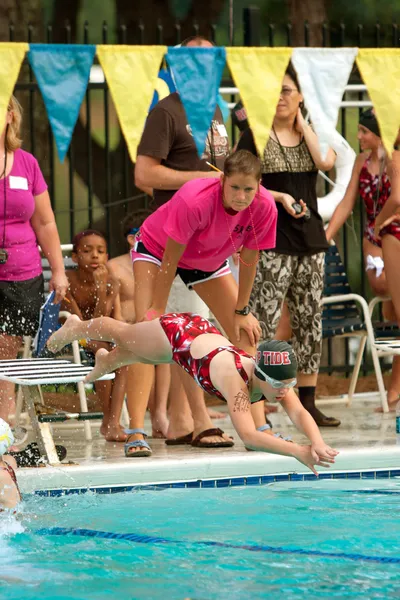 Enfant nageur plonge dans la piscine dans la rencontre de natation — Photo