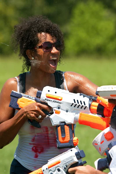 Женщина брызгает в лицо водяным пистолетом — стоковое фото