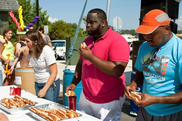 Tre concorrenti competono in concorso di mangiare hot dog — Foto Stock