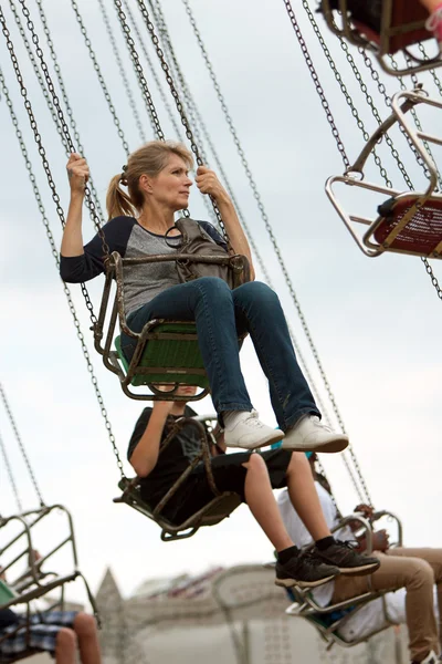 Erwachsene Frau reitet Schaukel bei Kreisfest — Stockfoto