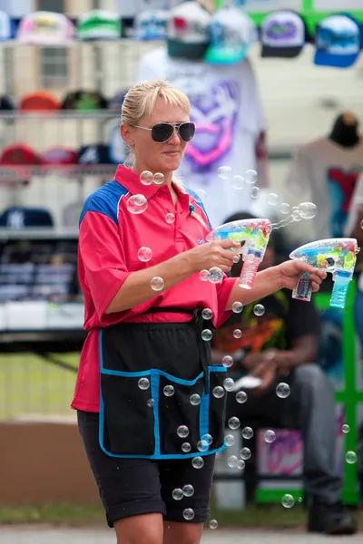 Trabalhador de Carnaval sopra bolhas com armas de bolha — Fotografia de Stock