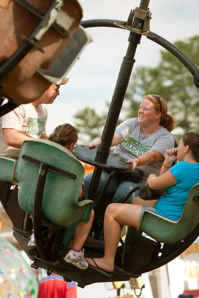 家族はカウンティー フェアでカーニバルに乗ってを楽しんでください。 — ストック写真