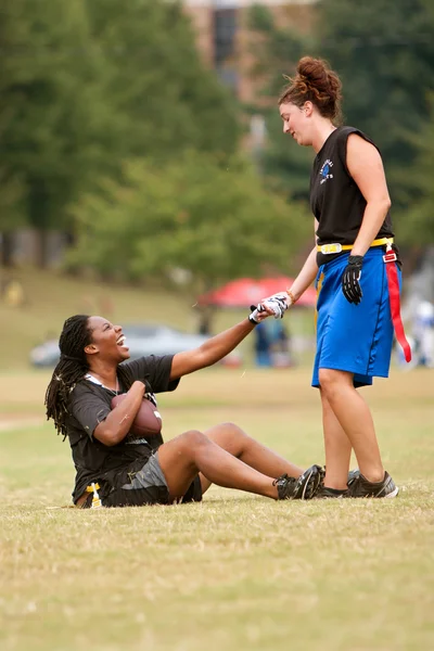 Jugadora de fútbol femenino de bandera ayuda a su compañero de equipo a levantarse —  Fotos de Stock