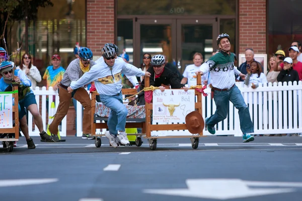 El equipo empuja la cama para terminar la línea en carrera del colchón — Foto de Stock