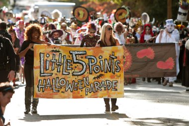 Women Carry Banner That Starts Halloween Parade clipart