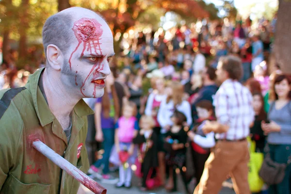 Zombie masculino com ferimento de facada caminha no desfile de Halloween — Fotografia de Stock