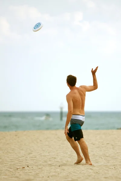 남자는 플로리다 해변에 프리즈 비를 던져 — 스톡 사진