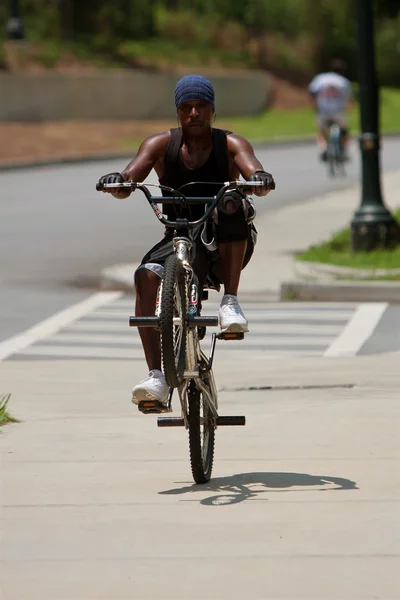 Jovem Pops uma roda na bicicleta e monta-lo — Fotografia de Stock