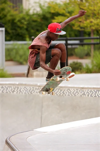 L'adolescent attrape de l'air tout en pratiquant le skateboard Sautez hors du bol — Photo